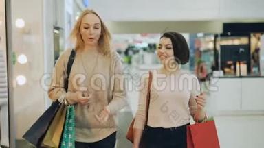 漂亮的金发女郎正在和她漂亮的女朋友<strong>逛街</strong>，聊天，微笑着在商场里散步，然后看着